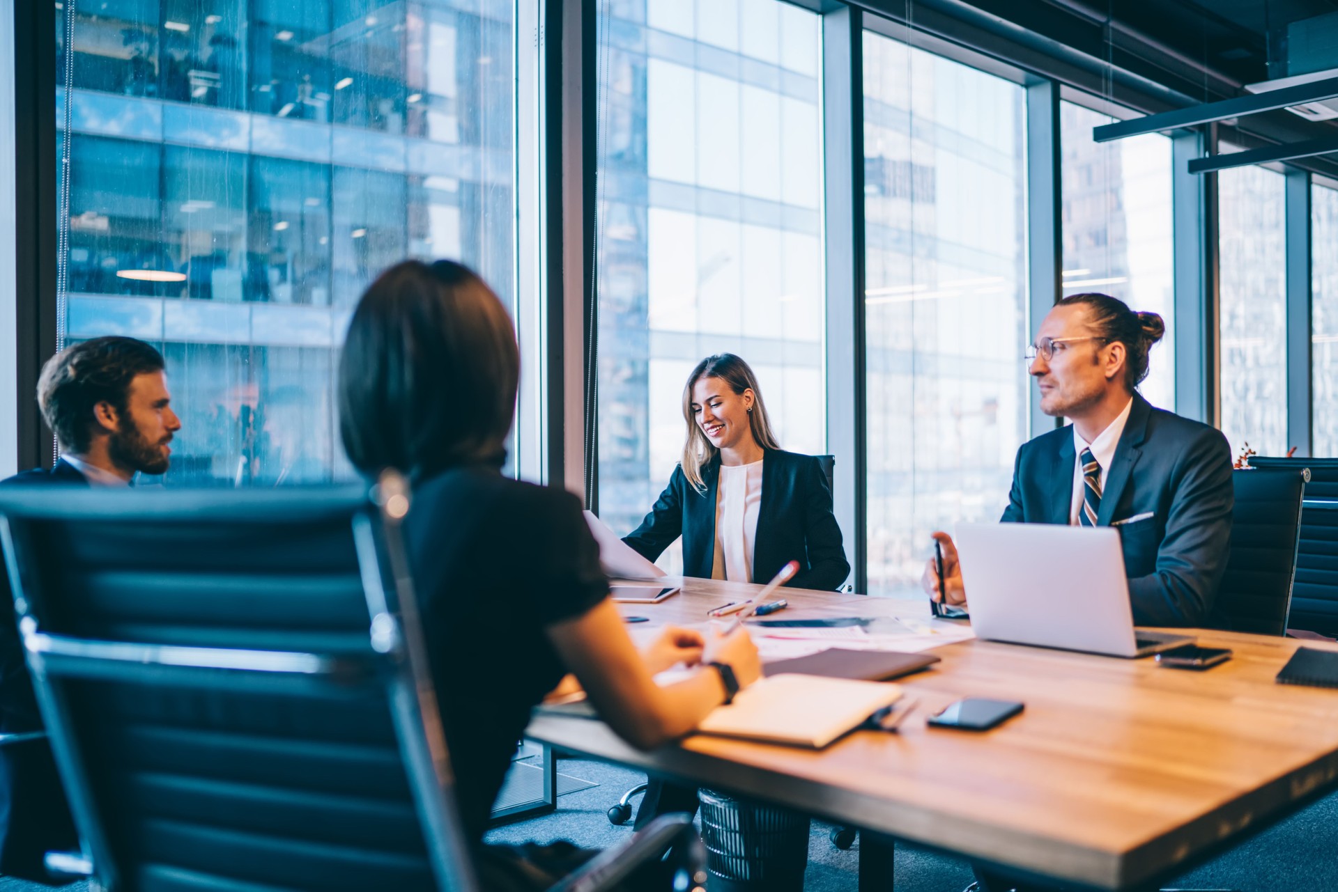 Prosperous team of financial experts in elegant formal wear discussing business planning during productive cooperation in firm, successful woman and man employees consulting about startup together